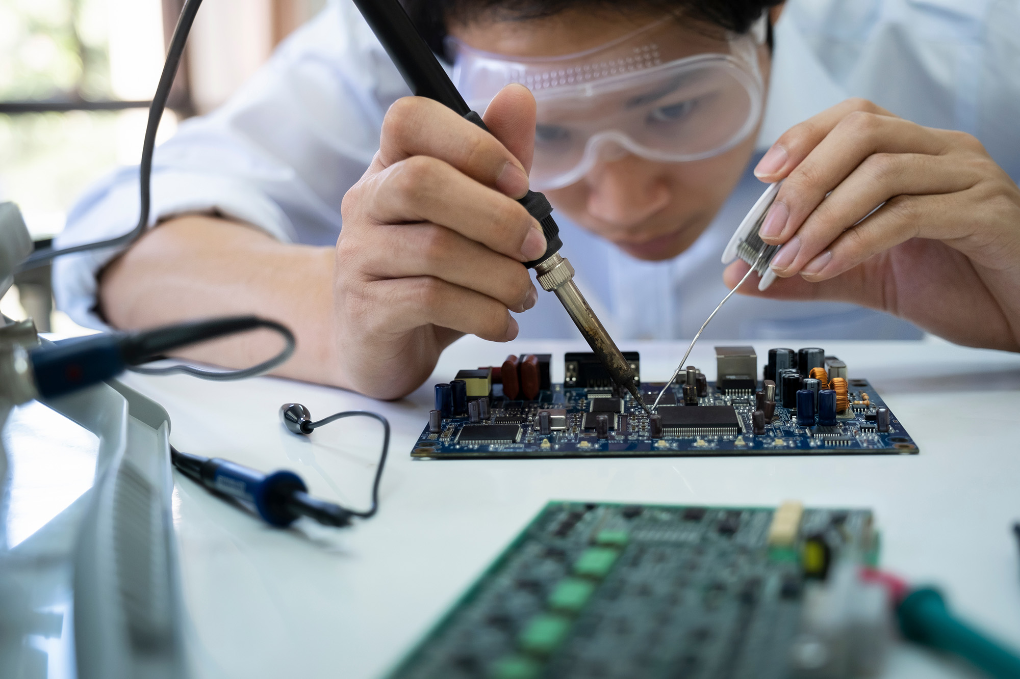 Viant technician inspecting high precision electronics for bioelectronic medical device assembly
